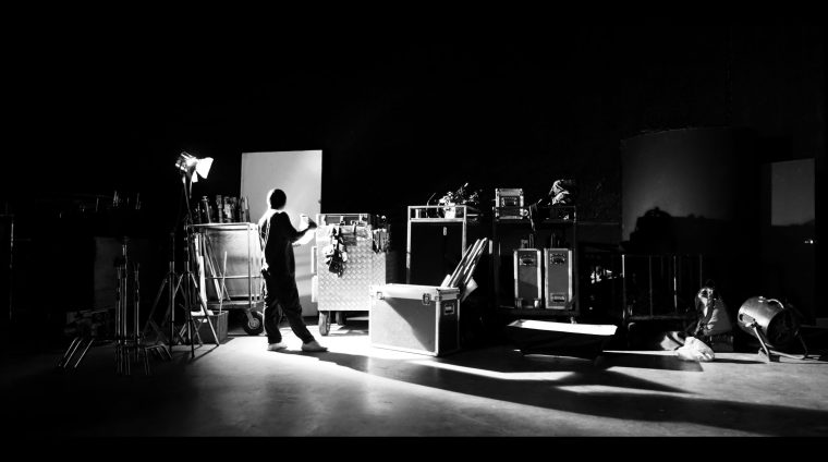 Behind the shooting production crew team and silhouette of camer Behind the shooting of video online commercial production and film crew team working and setting light or camera or soft box and equipment set up in big studio in silhouette style
